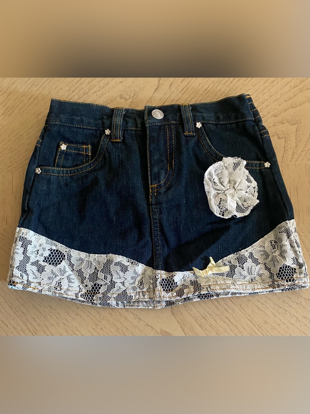 French Toast Dark Blue Denim Mini Skirt with White Lace Flower & Bow Appliqué.